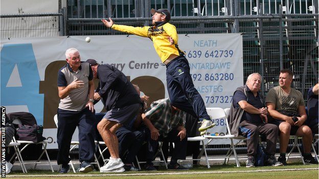 Glamorgan's Tom Cullen crashes into spectators as he attempts to catch a ball heading for six