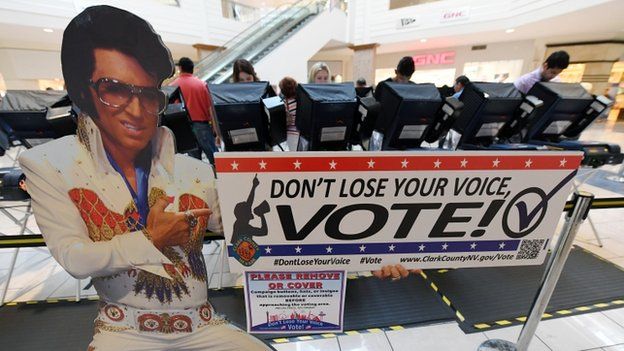 People vote early behind an Elvis Presley themed cardboard cutout in Las Vegas, Nevada