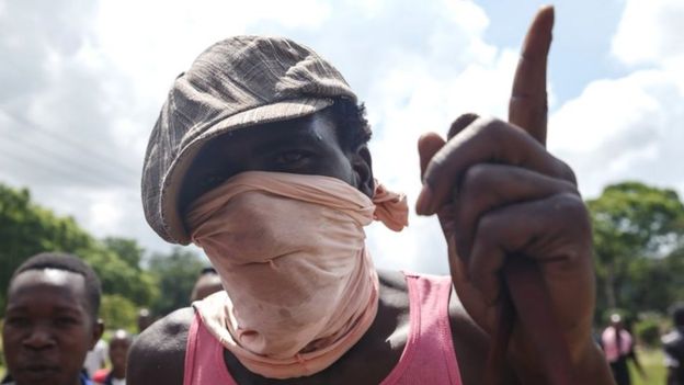 A man gestures as angry protesters barricade the main route to Zimbabwe"s capital Harare from Epworth township on January 14 2019 after announced a more than hundred percent hike in fuel prices