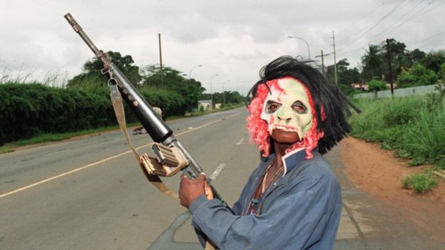 Un enmascarado rebelde leal al señor de la guerra Charles Taylor, del Frente Nacional Patriótico de Liberia, sostiene un arma mientras patrulla las calles de Monrovia en 1990.