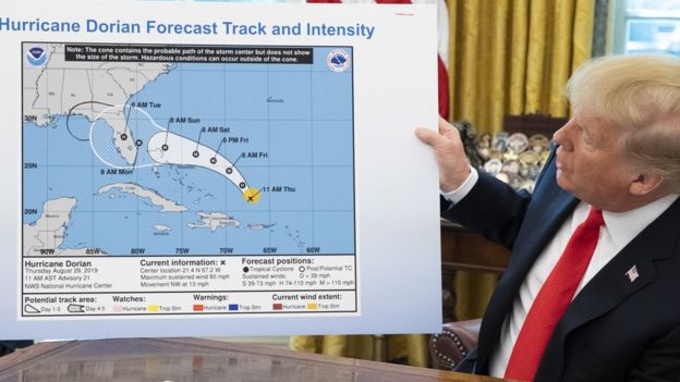 US President Donald Trump holds up a NOAA map of a previously projected path of Hurricane Dorian