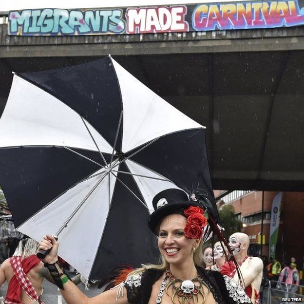 A performer keeps the rain at bay with a black and white brolly