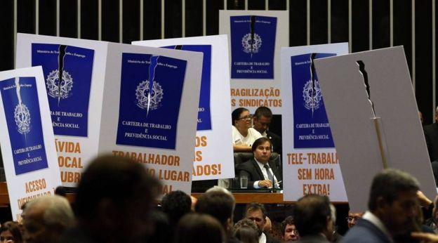 Manifestantes contra a reforma trabalhista empunham cartazes no plenário da Câmara dos Deputados