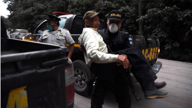 Police evacuate an elderly man in Alotenango, Guatemala 3 June 2018