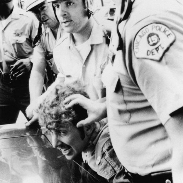 Cảnh sát Chicago bắt một sinh viên vì trèo lên cột để "treo cờ Việt Cộng" tại Đại hội của Đảng Dân chủ Mỹ tại Illinois ngày 26/08/1968