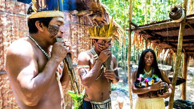 Índios brasileiros tocando instrumentos