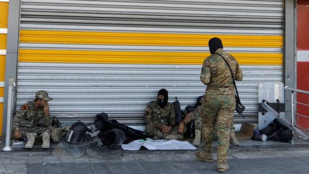 Iraqi security forces take a moment's rest in Tahrir Square during anti-government protests in Baghdad on 5 October 2019