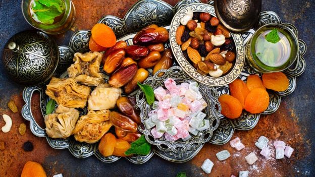 An Eid dish containing dates, almonds, dried fruit and mint tea