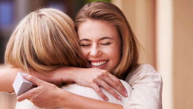 امرأة تعانق صديقتها بعد تبادل الهدايا