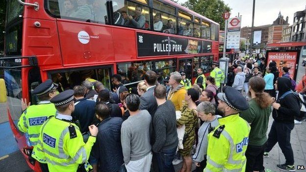 People try to board a bus in Stratford