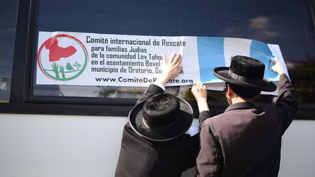 Miembros de Lev Tahor cuelgan una pancarta en un autobús en Guatemala, en 2016