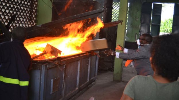 Man throwing a box into a fire