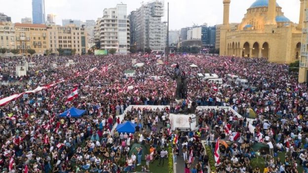 A picture taken with a drone shows an aerial view for protesters wave Lebanese flags and shout anti-government slogans during a protest in front of Muhammad al-Amin Mosque in downtown Beirut, Lebanon, 20 October 2019.