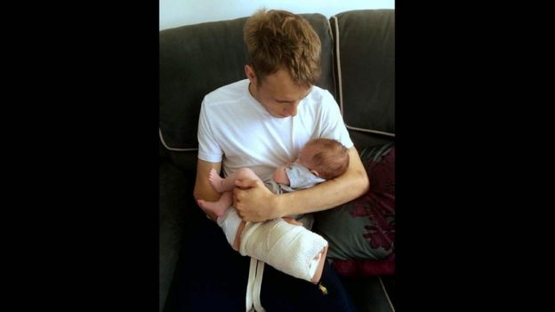 Alex com o bebê Iris após receber alta do hospital