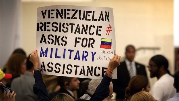 Una mujer sostiene un cartel en la reunión de venezolanos con Mike Pence