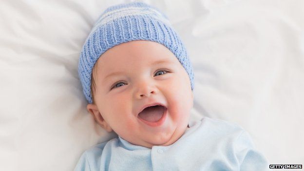 Laughing baby boy in blue hat