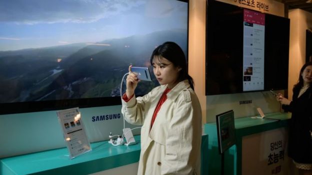 Woman looks at looks at a Samsung Galaxy S10 5G smartphone during a Korea Telecom 5G launch event in Seoul on 5 April 2019