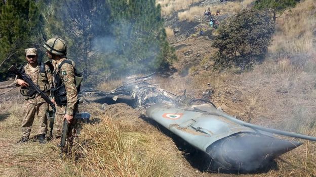 Soldados paquistaníes cerca de uno de los dos aviones indios derribados