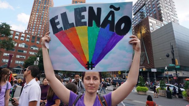 Mujer sosteniendo un cartel que dice "EleNão".