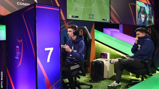Max Emilov Popov of Complexity Gaming competes in the final match of the FIFA eClub World Cup as team mate Joksan Redona Tello nervously looks on