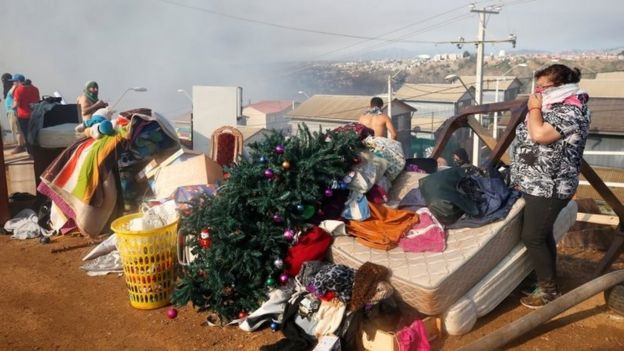People stand next to their personal belongings in Valparaíso, Chile. Photo: 24 December 2019