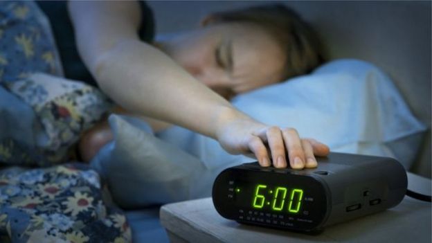 Mujer apagando la alarma del despertador