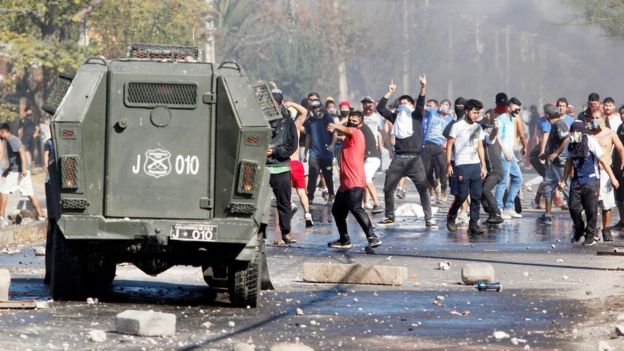 Manifestantes protestan frente a un camión de los carabineros.