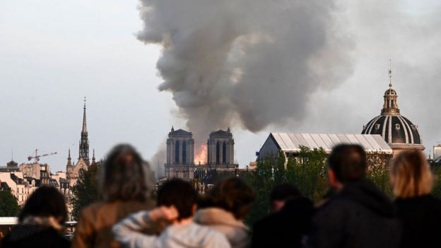 People watch the landmark Notre-Dame Cathedral burning in central Paris on April 15, 2019