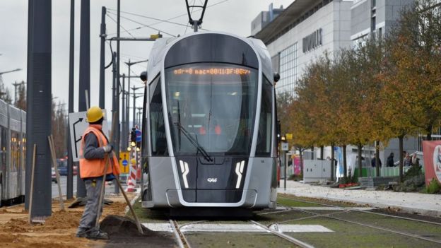 Trabajador frente a un tren de Luxemburgo