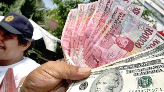 Cambista na Indonésia com rúpias e dólares