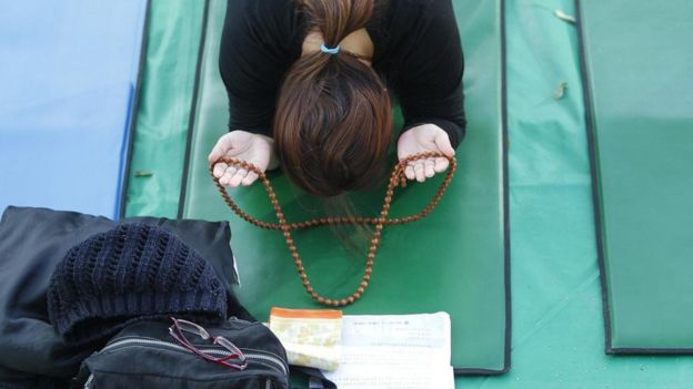 Mujer con rosario.