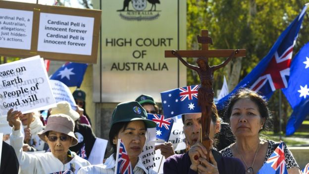 Supporters of George Pell carry crosses and signs outside the High Court of Australia during his appeal hearing