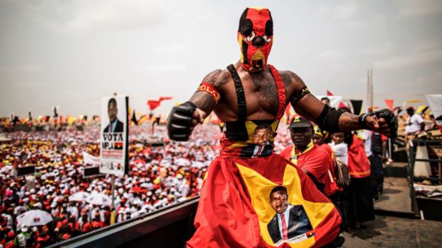 A wrestler poses on top of a truck overlooking a crowd attending an electoral meeting by Angolan President and The People's Movement for the Liberation of Angola President Jose Eduardo dos Santos and MPLA presidential Candidate Joao LourenÃ§o