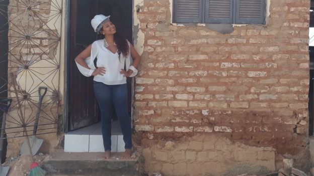 Fernanda Silmara Silva dos Santos em frente à casa que ajudou a reformar em projeto voluntário