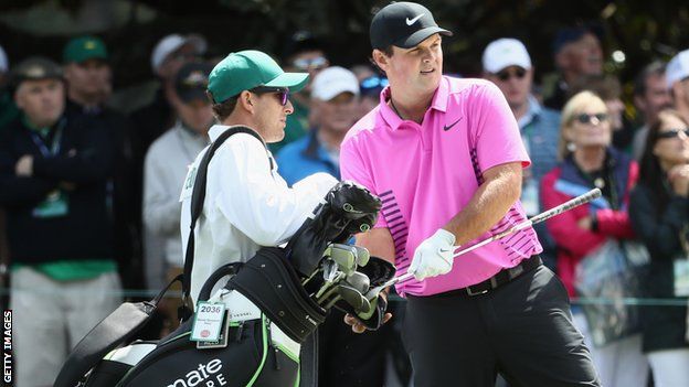 Patrick Reed talks with his caddie Kessler Karain on the first hole during the final round of the 2018 Masters