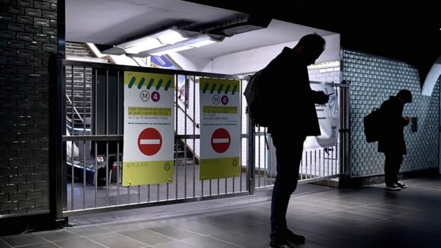 Passengers stand in front of the closed gates of the Châtelet metro station in Paris on 10 December 2019