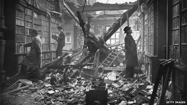 Men look at books in bomb damaged library