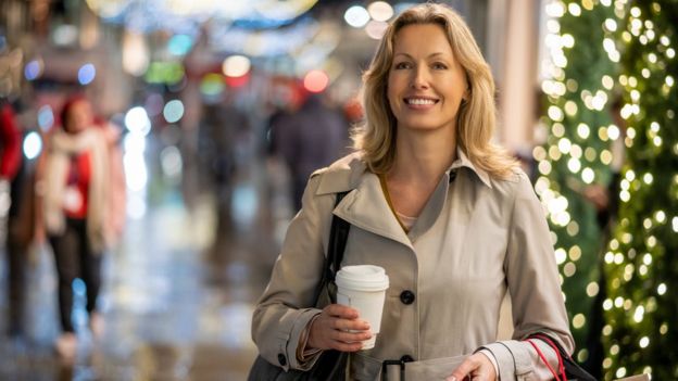 Woman with a takeaway coffee Christmas shopping