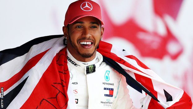 Lewis Hamilton celebrates while holding the Union flag