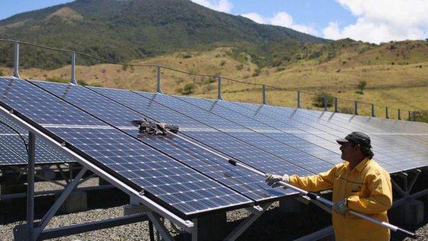 Homem limpa painéis solares na Costa Rica em 2015