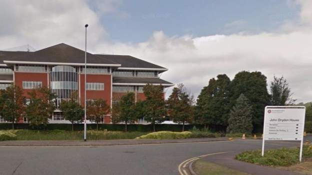 Four storey modern brick-built office building with trees in foreground