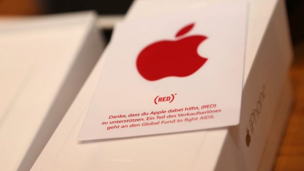 A sticker with the (RED) logo is seen on an iPhone box at the Apple Store on December 1, 2014 in Berlin, Germany