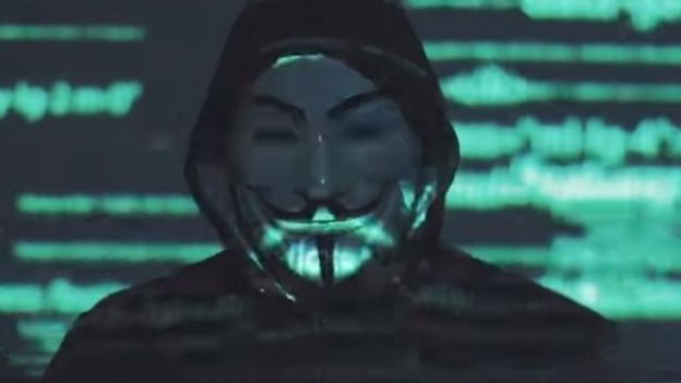 Um homem com uma máscara de Guys Fawkes em um vídeo retirado do Facebook