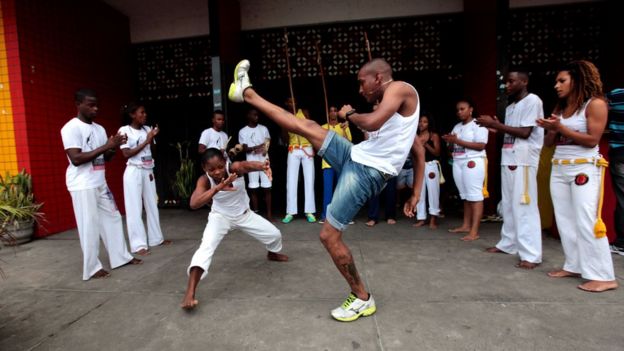 Jovens jogam capoeira