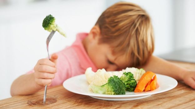 Un niño que no quiere comer verduras.