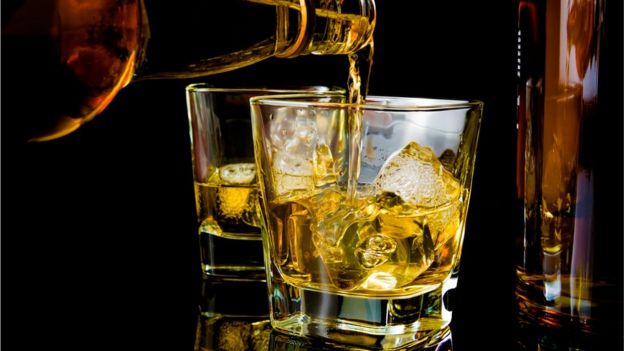 Colocando whisky em copo