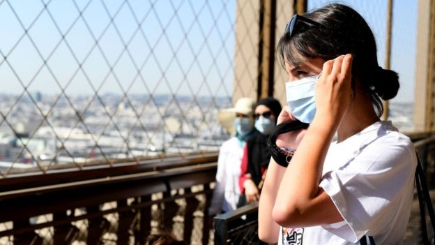 Una chica con mascarilla en la reapertura de la Torre Eiffel.