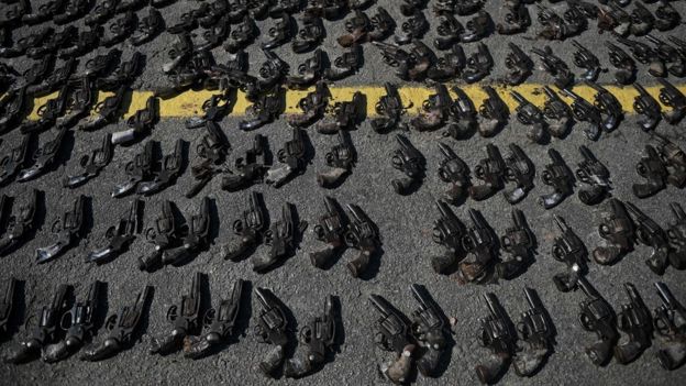 Armas apreendidas de bandidos pelas Forças Armadas no Rio de Janeiro, dispostas no asfalto para serem destruídas, em junho de 2018