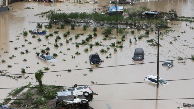 Cars are partially submerged in flood water