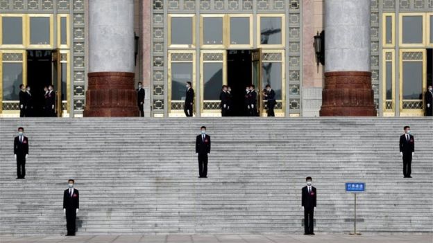 Security personnel wearing face masks following the coronavirus disease (COVID-19) outbreak stand guard outside the Great Hall of the People before the opening session of the National People"s Congress (NPC) in Beijing, China May 22, 2020.